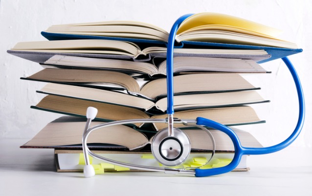 A stack of books with a stethoscope on top, symbolizing the combination of medical knowledge and Neet study.